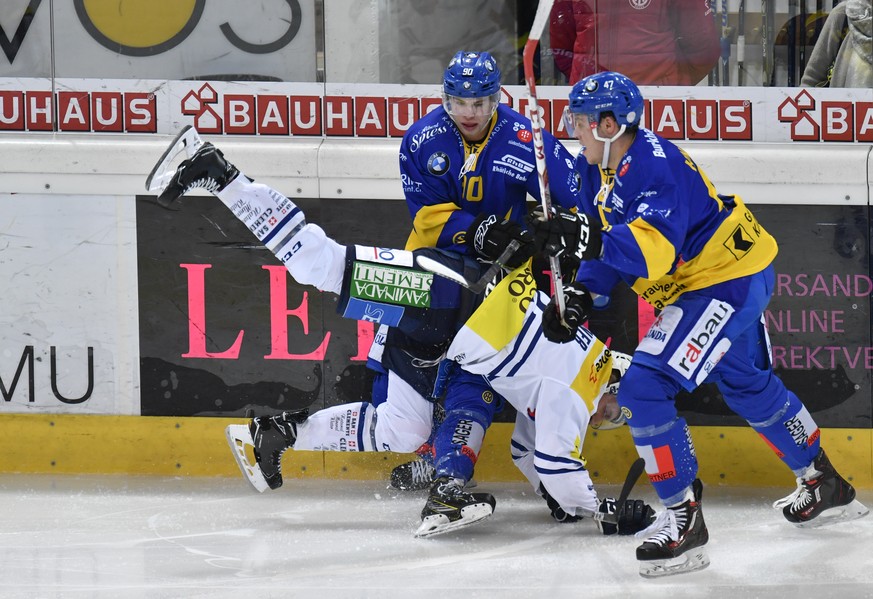 Die Davoser Sven Jung, links, und Simon Kindschi, rechts, zwingen Ambris Diego Kostner in den Handstand, beim Eishockey Meisterschaftsspiel der National League A zwischen dem HC Davos und Ambri Piotta ...