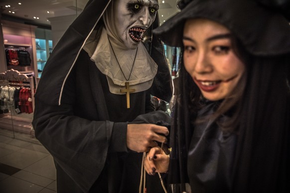 epa07962848 People wearing costumes and make-up participate in a celebration of Halloween at a shopping mall area, in Beijing, China, 31 October 2019. Halloween is celebrated on 31 October mostly in r ...