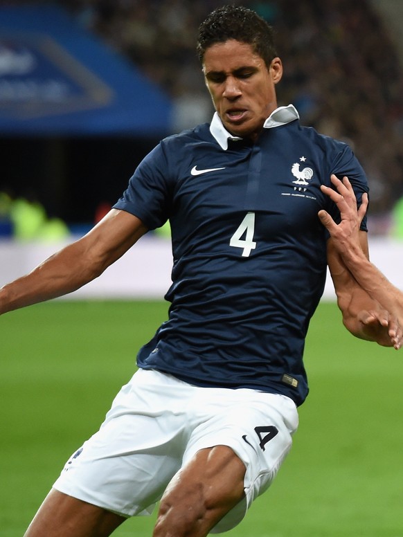 PARIS, FRANCE - NOVEMBER 13: Raphael Varane of France (L) is tackled by Jonas Hector of Germany during the International Friendly match between France and Germany at the Stade de France on November 13 ...