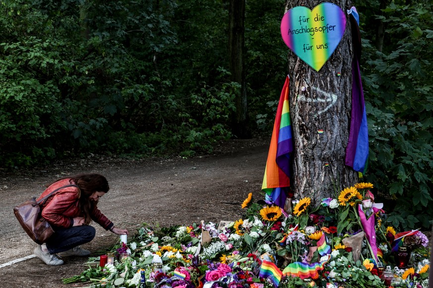 epa13135458 A woman lights a candle at a mourning site near the scene where a vehicle plowed into a crowd on the sideline of the Christopher Street Day (CSD) parade in Berlin, Germany, 27 July 2026. T ...