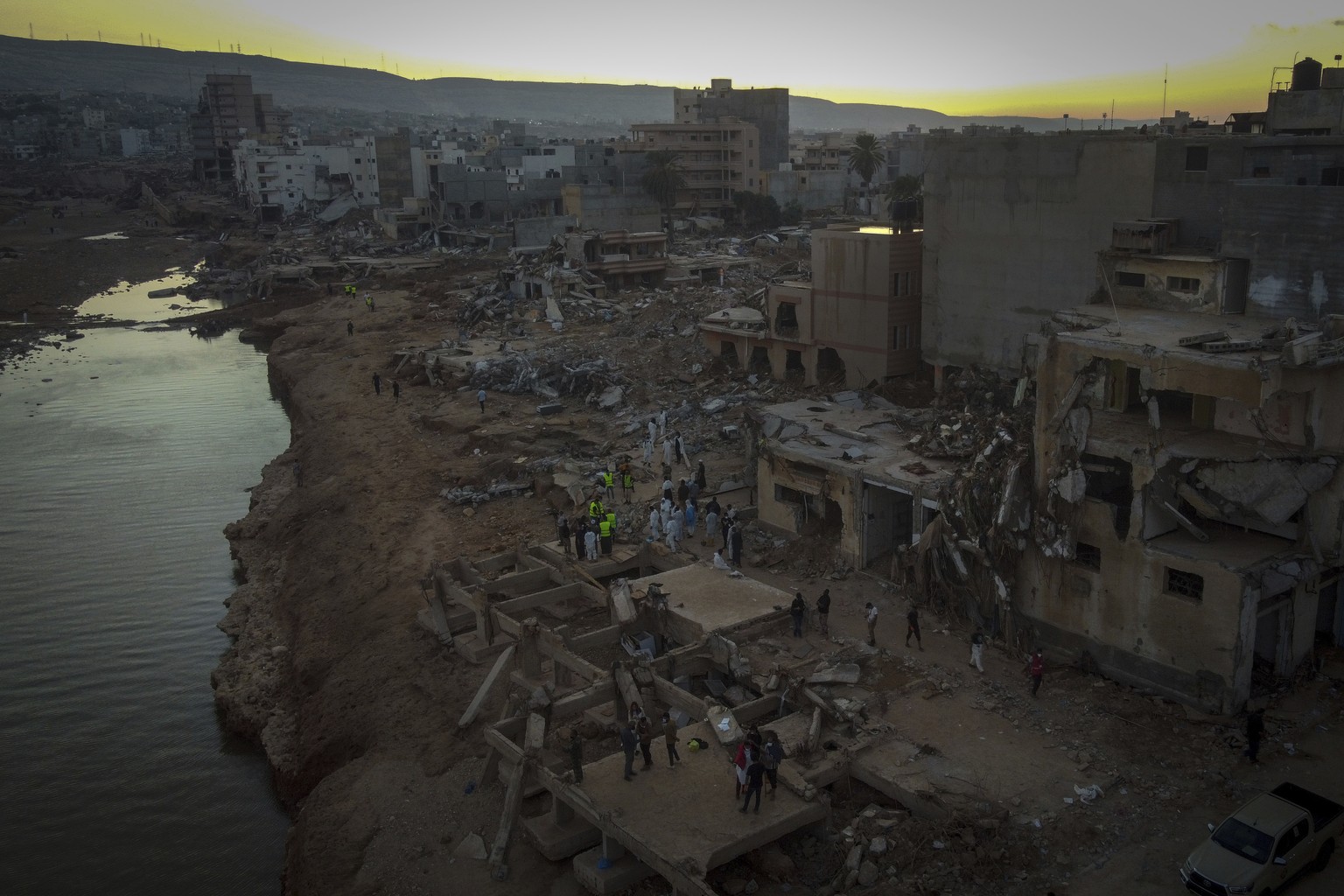 FILE - People search for flood victims in Derna, Libya, Friday, September 15, 2023. For many Libyans, the disastrous flood that killed more than 11,000 people has fostered a sense of unity.  The collection...