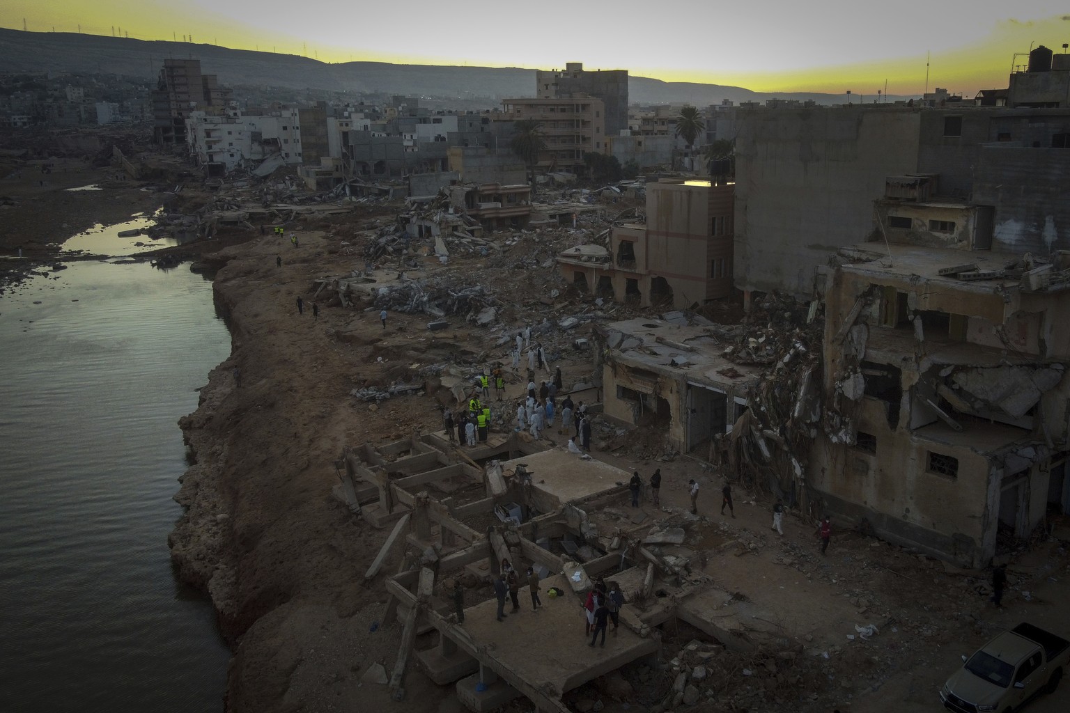 FILE - People search for flood victims in Derna, Libya, Friday, Sept. 15, 2023. For many Libyans, the disastrous flooding that killed more than 11,000 people have fostered a sense of unity. The collec ...