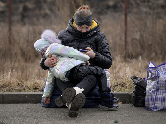 Refugees that fled the conflict from neighboring Ukraine await transportation at the Romanian-Ukrainian border, in Siret, Romania, Sunday, Feb. 27, 2022. Since Russia launched its offensive on Ukraine ...