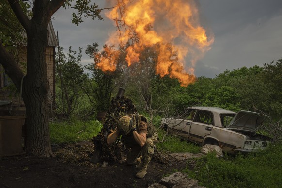 A Ukrainian soldier fires a mortar at Russian positions on the frontline near Bakhmut, Donetsk region, Ukraine, Sunday, May 28, 2023. (AP Photo/Efrem Lukatsky)