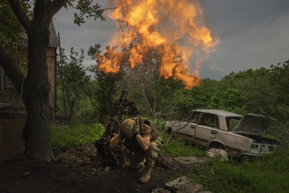 A Ukrainian soldier fires a mortar at Russian frontline positions near Bakhmut, Donetsk region, Ukraine, May 28, 2023. (AP Photo/Efrem Lukatsky)