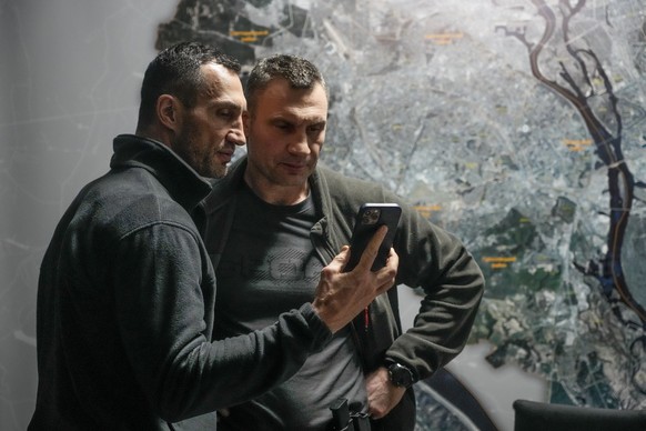 Vitali Klitschko, Kyiv Mayor and former heavyweight champion, right, and his brother Wladimir Klitschko, a Ukrainian former professional boxer look at a smart phone in the City Hall in Kyiv, Ukraine,  ...