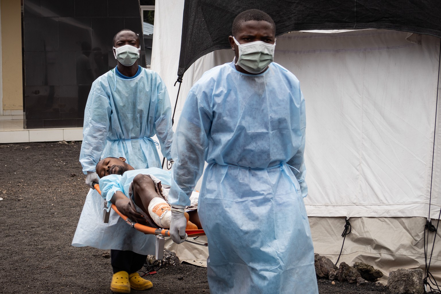 epa11876999 Medical workers carry a patient wounded during fighting between the Armed Forces of the Democratic Republic of the Congo (FARDC) and the M23 rebels, in Kyeshero Hospital in Goma, North Kiv ...