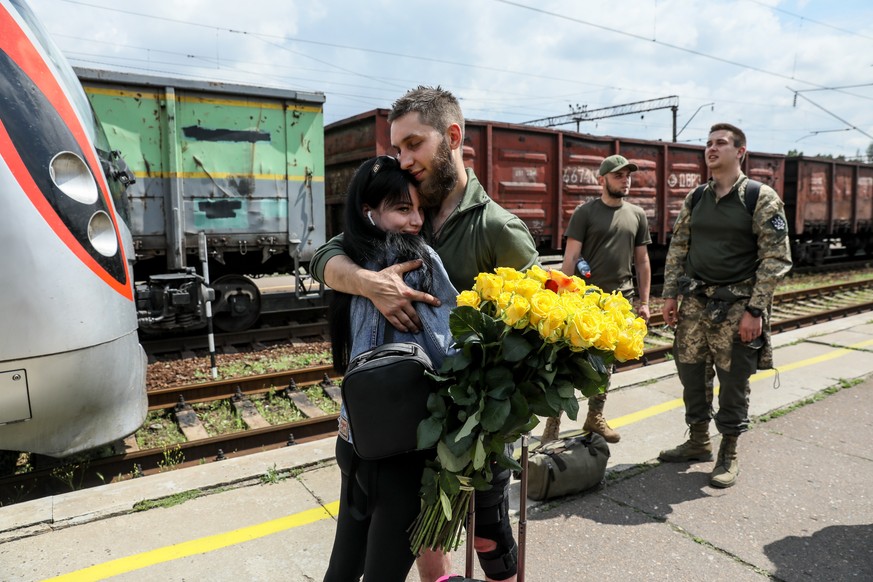 epa10660084 A couple hug at the railway station in Kramatorsk, Donetsk region, Ukraine, 28 May 2023. Under martial law, Ukrainian servicemen are entitled to 10 days of vacation per year. Some of their ...