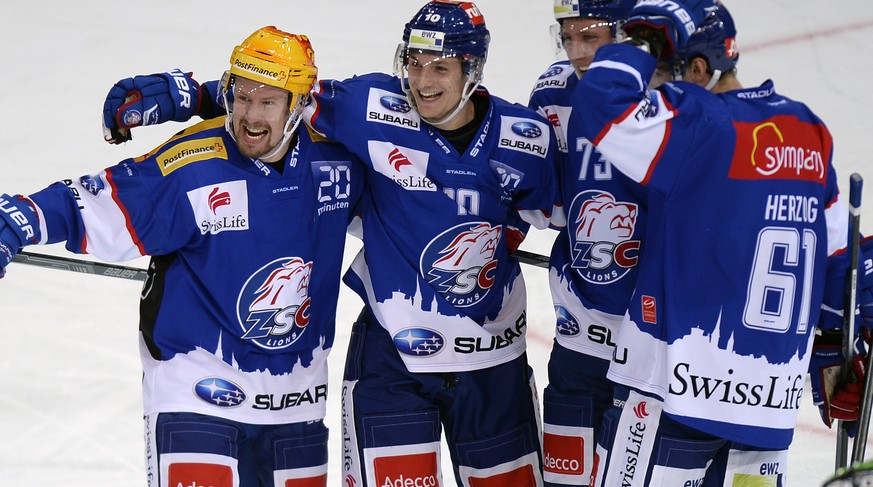 Die Zuercher um Mathias Seger, links, und Cedric Haechler, zweiter von links, jubeln nach dem 4-3 beim Eishockeyspiel der National League A ZSC Lions gegen den SC Bern im Hallenstadion in Zuerich am M ...