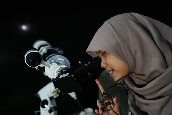 A woman uses a telescope, provided by Planetarium Jakarta, to watch the moon rising in Jakarta, Indonesia, Wednesday, Nov. 5, 2025. (AP Photo/Tatan Syuflana)
Indonesia Supermoon