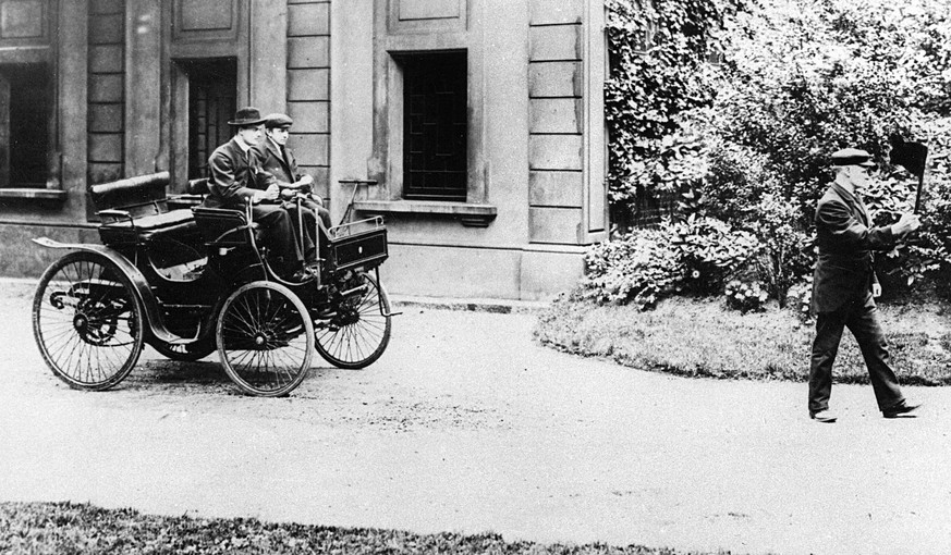 &quot;The Red Flag Act&quot; zur Verhinderung von Verkehrsunfällen: Charles Rolls am Steuer eines Peugeot um 1896; vorneweg geht ein Fussgänger mit Warnflagge.

https://de.wikipedia.org/wiki/Red_Flag_ ...
