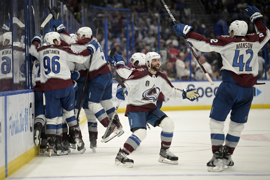 Colorado Avalanche center Andrew Cogliano, center, and defenseman Josh Manson (42) celebrate the overtime goal by teammate center Nazem Kadri (91) in Game 4 of the NHL hockey Stanley Cup Finals agains ...