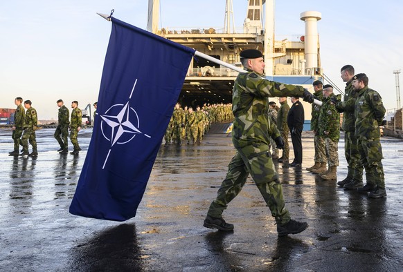 RIGA 2025-01-18 The NATO flag in front of the Swedish battalion. Soldiers and equipment from the Southern Skane Regiment P7 in Sweden arrived by ferry to the port of Riga to become part of NATO s Mult ...