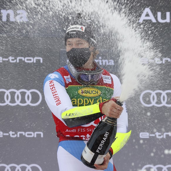 Switzerland's Marco Odermatt celebrates on the podium after winning the alpine ski World Cup men's giant slalom in Santa Caterina Valfurva, Italy, Monday, Dec. 7, 2020. (AP Photo/Alessandro Trovati)