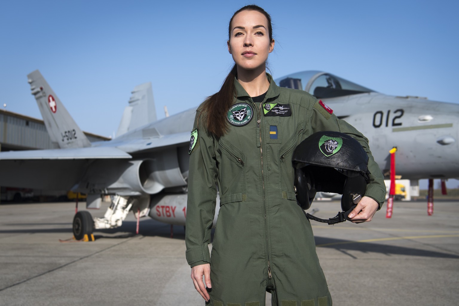 Fanny Chollet, the first female fighter pilot of the Swiss air force poses in front of a F/A-18 Hornet fighter jet after a press conference at the Swiss army airbase in Payerne, Tuesday, February 19,  ...