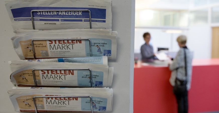 ARCHIVBILD ZUR JAHRESMEDIENKONFERENZ DES SCHWEIZERISCHEN GEWERKSCHAFTBUNDES -- [Staged photograph] A newspaper rack with vacancies, in the foreground left, is seen in focus while a counselor of the re ...