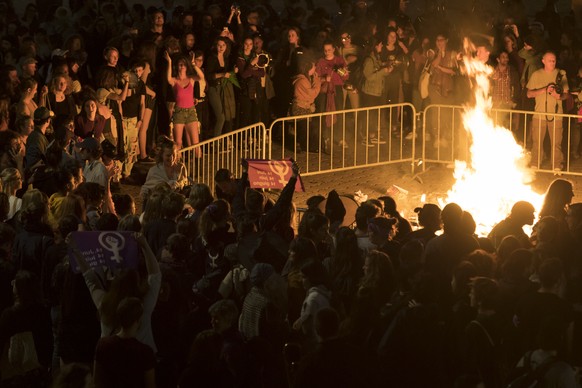 Des femmes brulent une pancarte dans un feu sur la place de la Riponne lors d’une action de lancement de la greve des femmes / greve feministe ce vendredi 14 juin 2019 a Lausanne. (KEYSTONE/Laurent Gi ...
