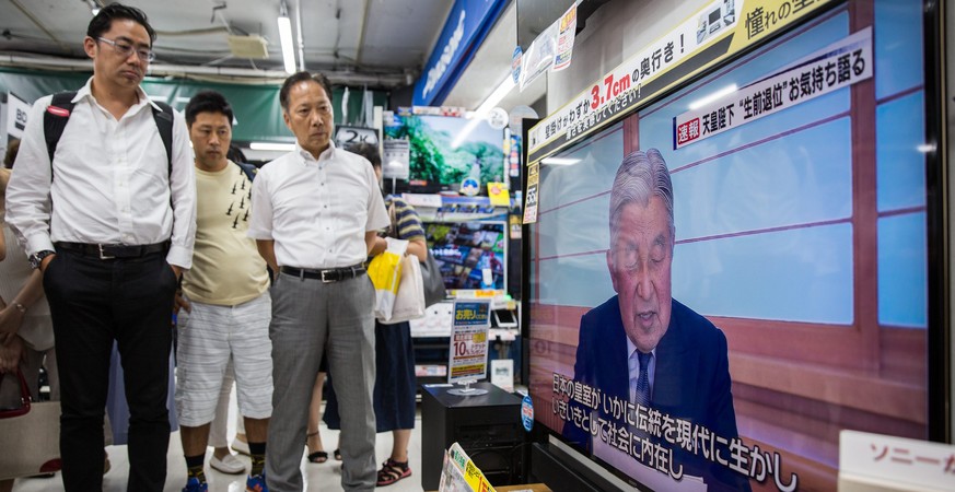 epa05464061 People in a electronics store in Tokyo, Japan, 08 August 2016 watch a TV screen broadcasting Japanese Emperor Akihito, 82, delivering a video message to the public. Japanese Emperor Akihit ...