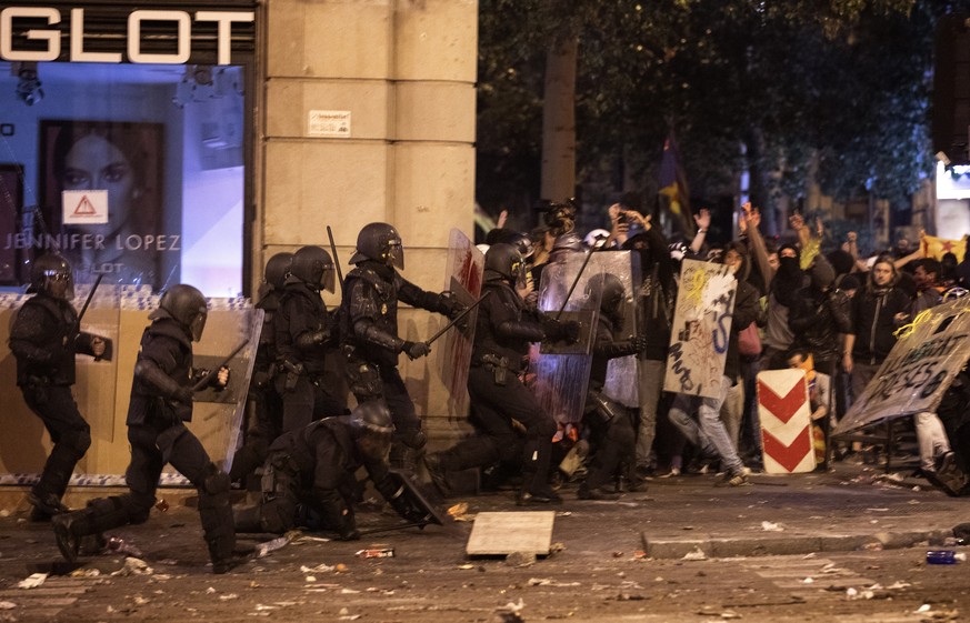 National police officers clash with demonstrator during clashes in Barcelona, Spain, Friday, Oct. 18, 2019.The Catalan regional capital is bracing for a fifth day of protests over the conviction of a  ...