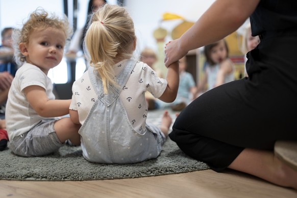 Kleinkinder sitzen gemeinsam mit Betreuungspersonal der Kita 6a der Stiftung GFZ im Kreis singen und machen Spiele, aufgenommen am 9. Juli 2020 in Zuerich. Die Kita 6a der Stiftung GFZ wird in Zusamme ...