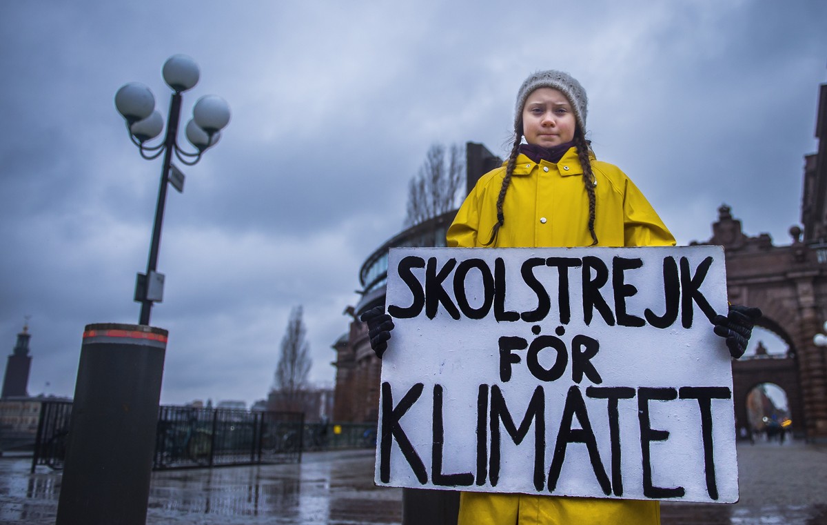 epa07199174 Swedish 15-year-old girl Greta Thunberg holds a placard reading 'School strike for the climate', during a protest against climate change outside the Swedish parliament in Stockho ...