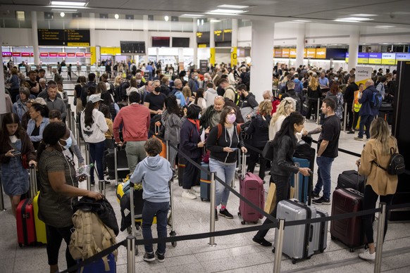 epa09987806 Travellers queue to check in for their flights at Gatwick Airport in London, Britain, 31 May 2022. Holidaymakers across the UK face continuing travel disruptions due to flight cancellation ...