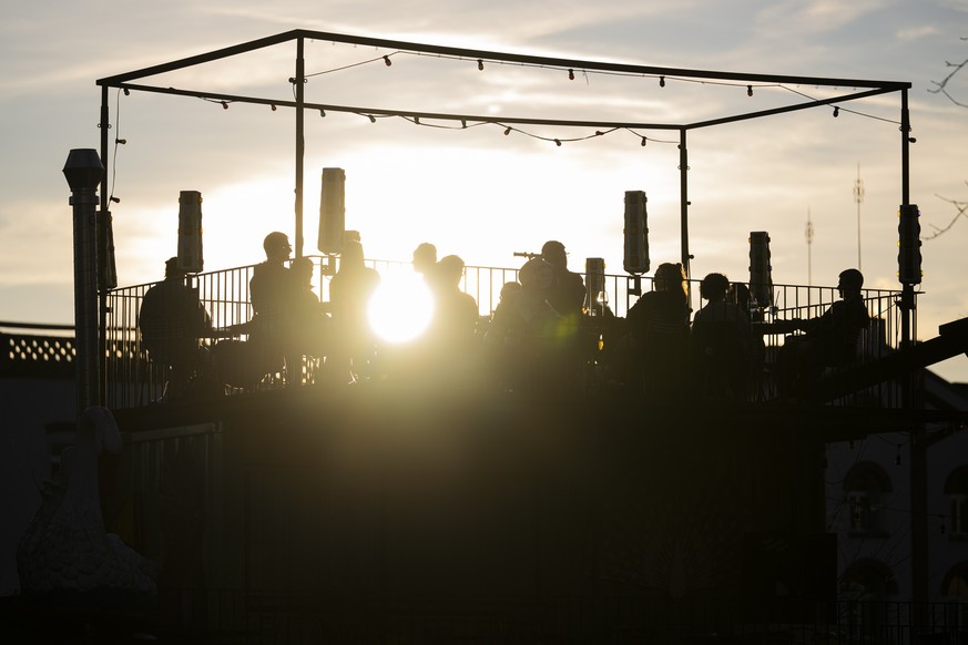 KEYPIX - Personen geniessen auf einer Terrasse die fruehlingshaften Temperaturen und den Sonnenuntergang, am Mittwoch, 25. Februar 2026 in Zuerich. (KEYSTONE/Andreas Becker)