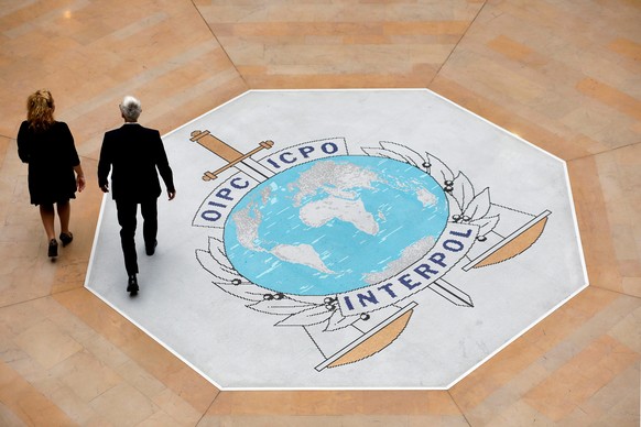 FILE - People walk on the Interpol logo at the international police agency headquarters in Lyon, central France, Nov. 8, 2018. (AP Photo/Laurent Cipriani, File)
Jurgen Stock