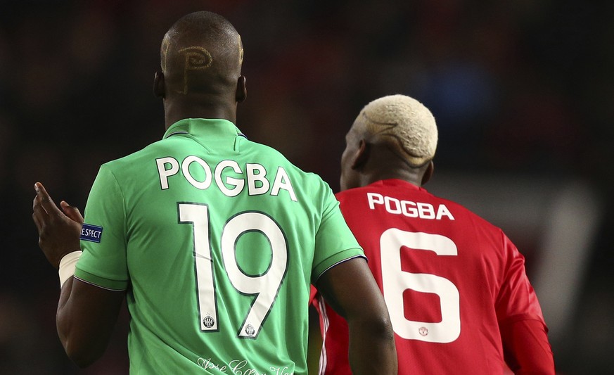 St.-Etienne&#039;s Florentin Pogba, left, and Manchester United&#039;s Paul Pogba enter the pitch after halftime during the Europa League round of 32 first leg soccer match between Manchester United a ...