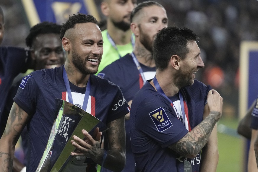 FILE - PSG&#039;s Neymar, left, holds the trophy as he celebrate with his teammate Lionel Messi after winning the French Super Cup final soccer match between Nantes and Paris Saint-Germain at Bloomfie ...