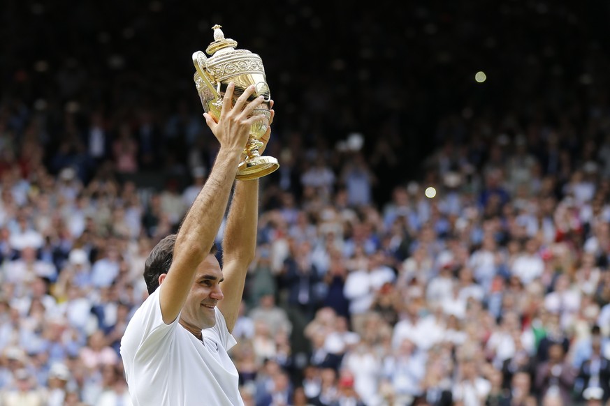 Roger Federer of Switzerland celebrates with the trophy after winning the men&#039;s final match against Marin Cilic of Croatia during the Wimbledon Championships at the All England Lawn Tennis Club,  ...