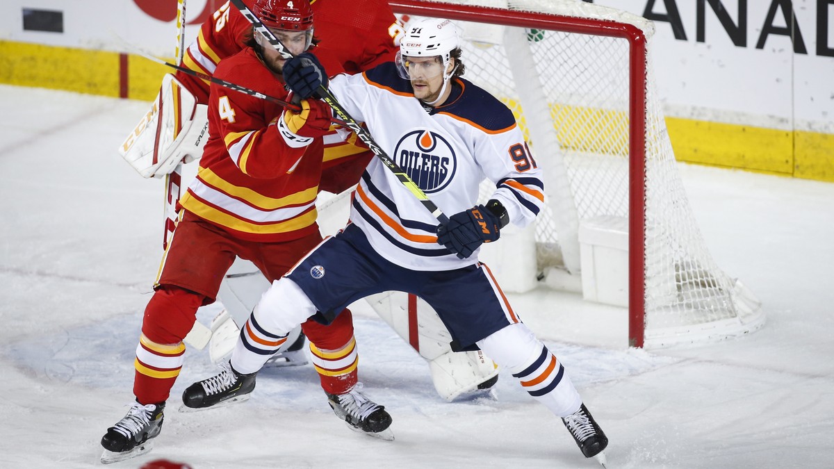 Edmonton Oilers' Gaetan Haas, right, and Calgary Flames' Rasmus Andersson tangle in front of goalie Jacob Markstrom during the first period of their NHL hockey game in Calgary, Monday, March ...