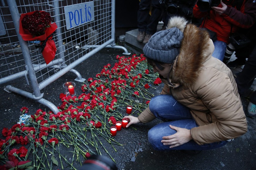 epa05694413 People place flowers and candles at a police barrier in front of the Reina night club following a gun attack at the popular night club in Istanbul close to the Bosphorus river, in Istanbul ...