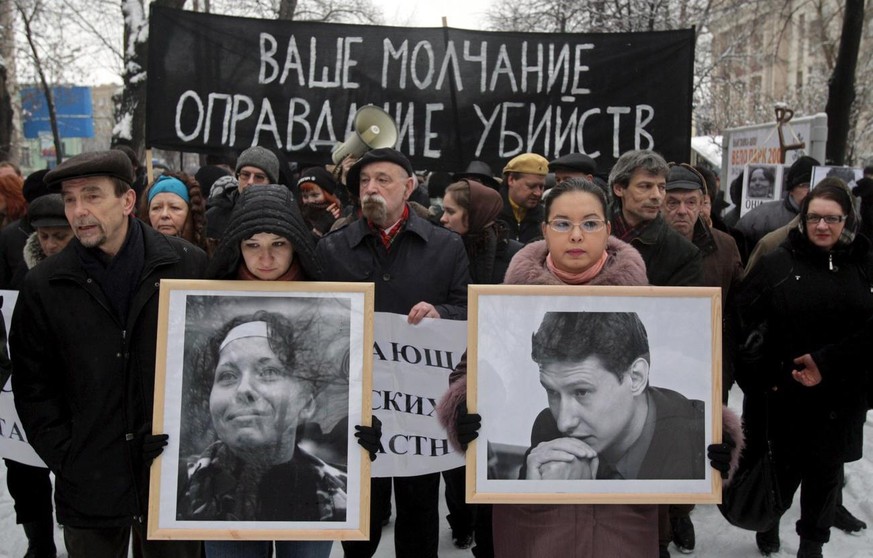 epa01637008 Opposition demonstrators hold portraits of killed lawyer Stanislav Markelov and journalist Anastasia Baburova during a rally in Moscow, Russia, 15 February 2009. Markelov, a lawyer who had ...