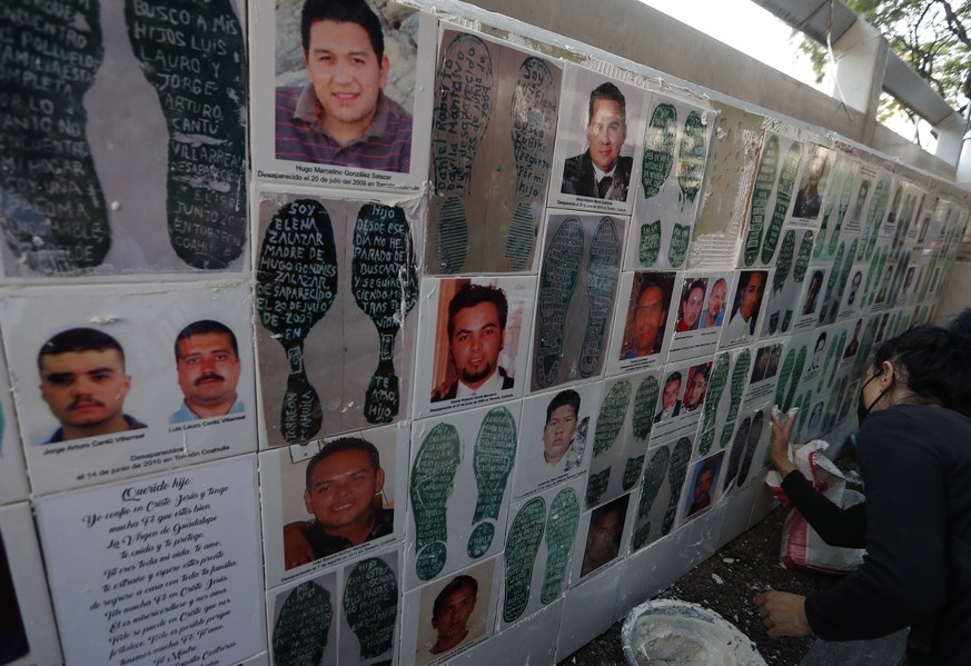 epa09936901 Mothers of missing persons, accompanied by members of the United Forces for Our Disappeared (FUNDEM) organization, place images of their loved ones in front of the headquarters of the Atto ...