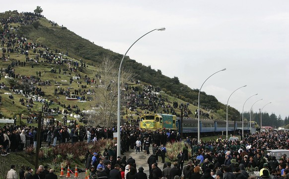 NGARUAWAHIA, NEW ZEALAND - AUGUST 21: Thousands of people wait on the road and the sacred Taupiri Mountain for the coffin of the Maori Queen Dame Te Atairangikaahu following its journey down the Waika ...