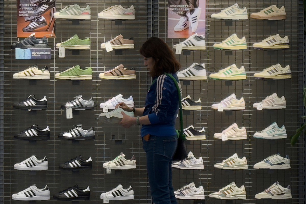 A woman tries out a shoe at an Adidas sportswear store inside a shopping mall, in Beijing, Saturday, April 12, 2025. (AP Photo/Andy Wong)
China Trump Tariffs