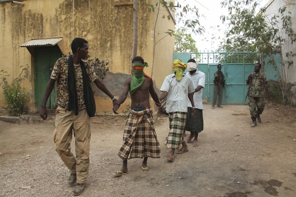 Mitglieder der Armee führen Verdächtige der Al Shabaab Miliz ab.