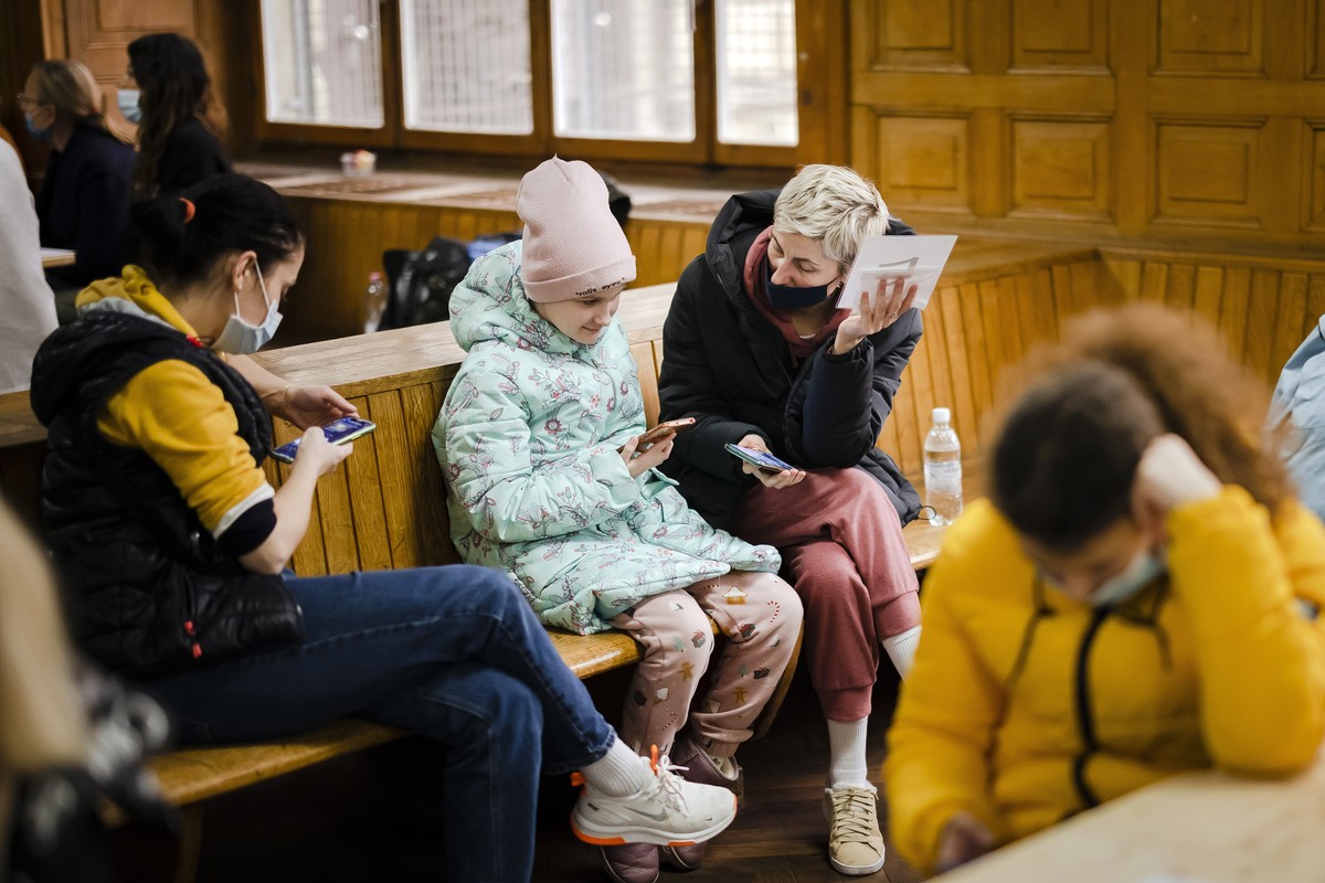 epa09826456 Women from Ukraine wait during the registration at the reception center for refugees, following Russia's invasion of Ukraine, in Zurich, Switzerland, 15 March 2022. According to figur ...