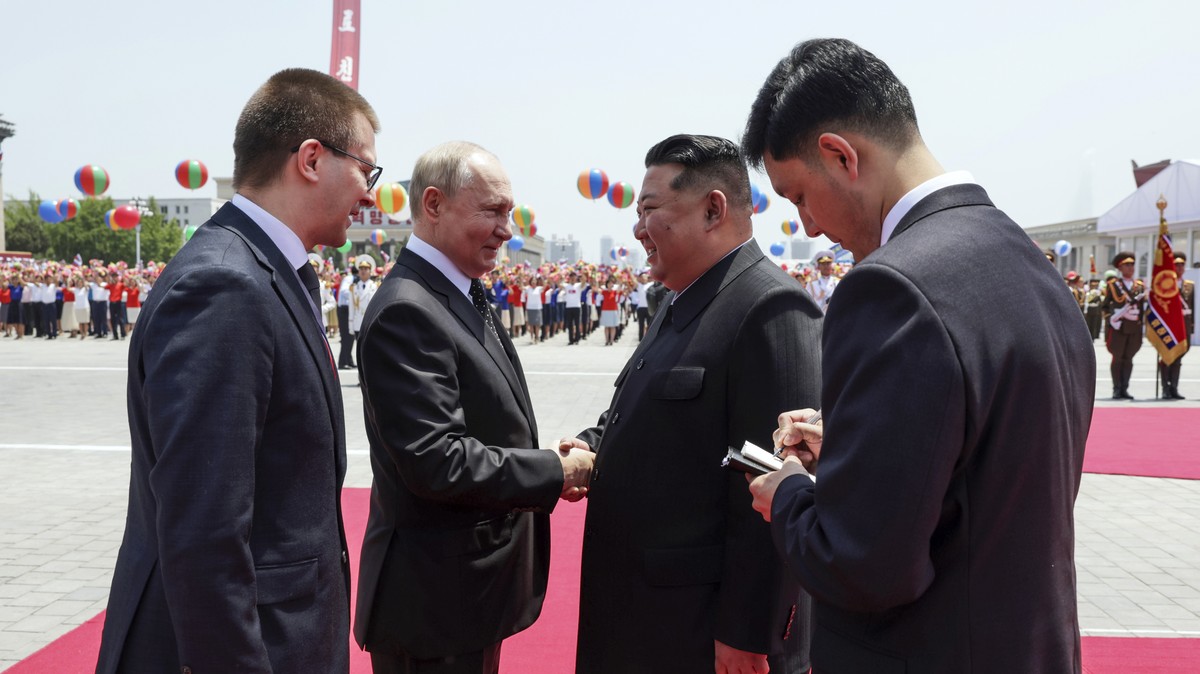 Russian President Vladimir Putin, second left, and North Korea's leader Kim Jong Un, second right, greet each other during the official welcome ceremony in the Kim Il Sung Square in Pyongyang, No ...
