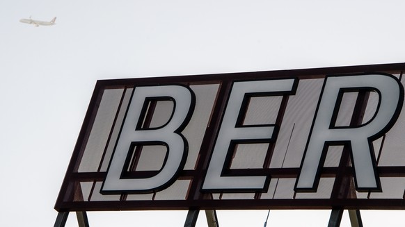 epa09029328 A plane flies over the BER logo during the last operation day of the T5 Terminal of the BER Berlin-Brandenburg airport near Berlin in Schoenefeld, Germany, 22 February 2021. The T5 Termina ...