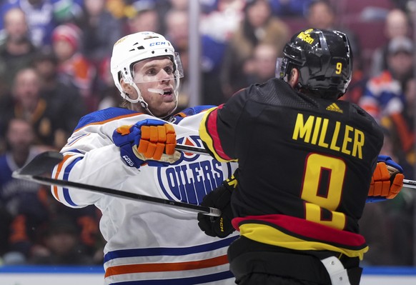 Edmonton Oilers&#039; Connor McDavid, left, checks Vancouver Canucks&#039; J.T. Miller during the third period of an NHL hockey game in Vancouver, British Columbia, on Monday, Nov. 6, 2023. (Darryl Dy ...
