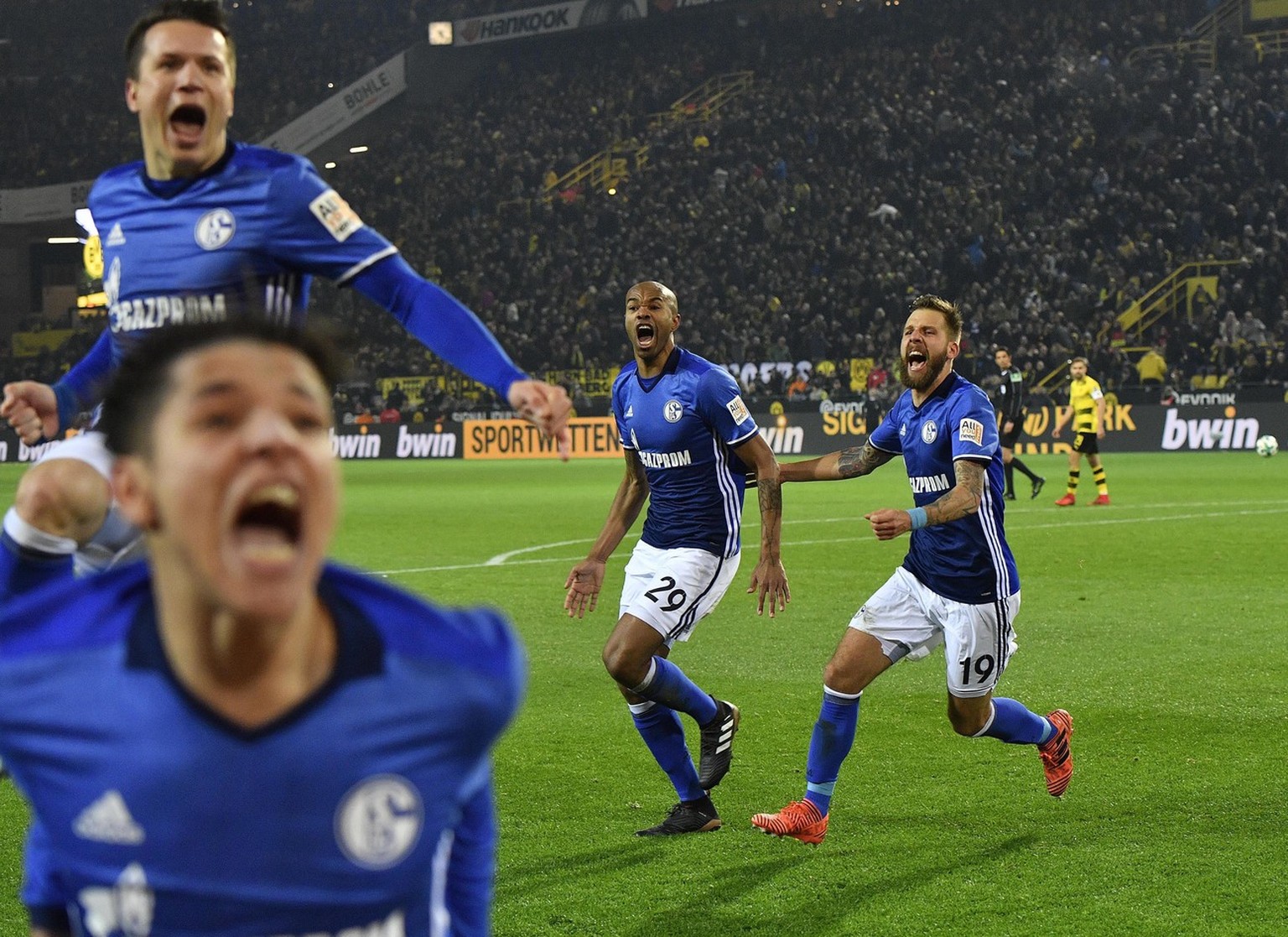 Schalke celebrates after Naldo, center, scored the last goal during the German Bundesliga soccer match between Borussia Dortmund and FC Schalke 04 in Dortmund, Germany, Saturday, Nov. 25, 2017. The ma ...