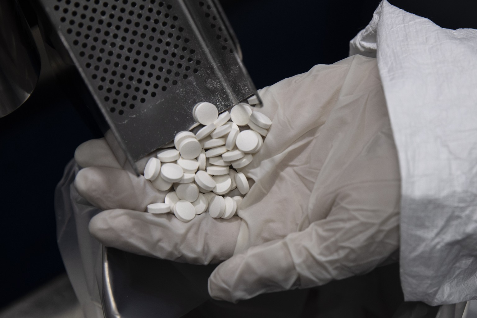 A lab technician holds avipiravir medication used to treat coronavirus, at the Eva Pharma facility in Cairo, Egypt, Sunday, July 12, 2020. Eva Pharma, a leading Egyptian pharmaceutical company is prod ...