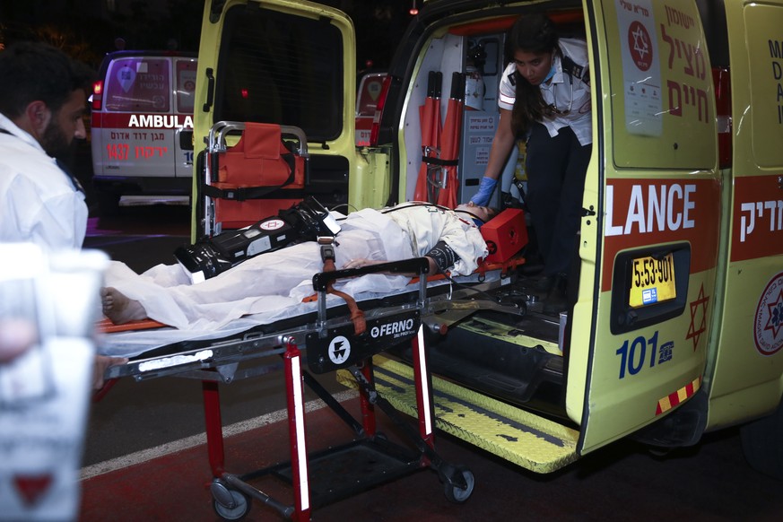 A person wounded in an attack is brought to a hospital in Tel Aviv, Israel, Friday, April 7, 2023. Israeli police said a car rammed into a group of people near a popular seaside park before flipping o ...