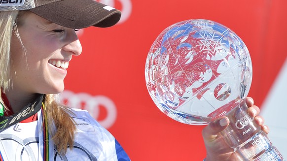 Lara Gut of Switzerland celebrates with the cristal globe of the overall women&#039;s Super G competition in the finish area after the women&#039;s Super G race at the FIS Alpine Ski World Cup finals, ...
