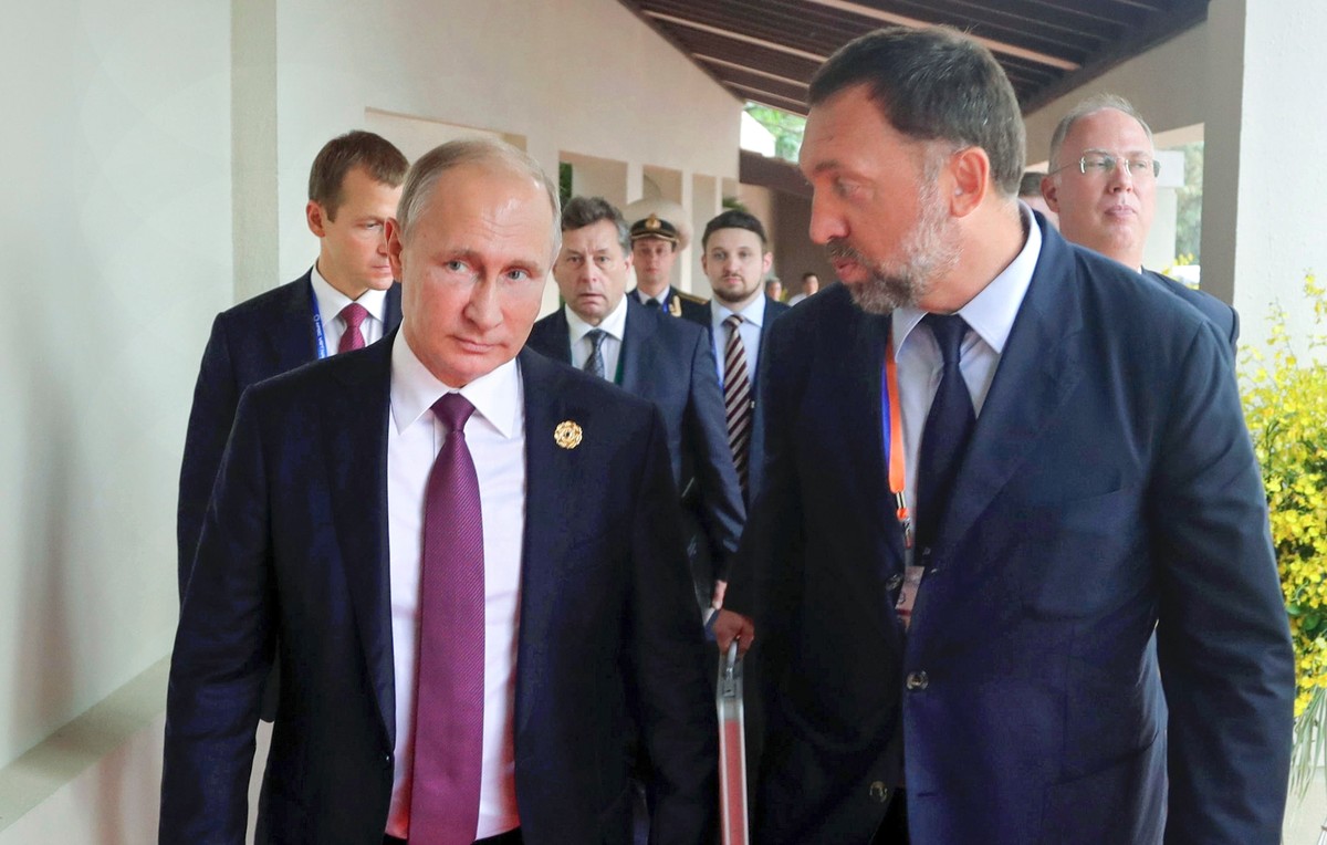 FILE - Russia's President Vladimir Putin, left, and Russian metals magnate Oleg Deripaska, right, walk to attend the APEC Business Advisory Council dialogue in Danang, Vietnam on Nov. 10, 2017. R ...