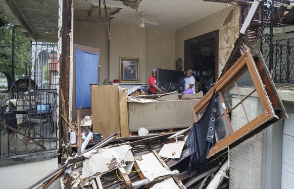 Christopher Atkins, left, helps his friend, George Soloman, remove a TV and other items from his Banks Street home Monday, Aug. 30, 2021, after a wall collapsed and roof was damaged during Hurricane I ...