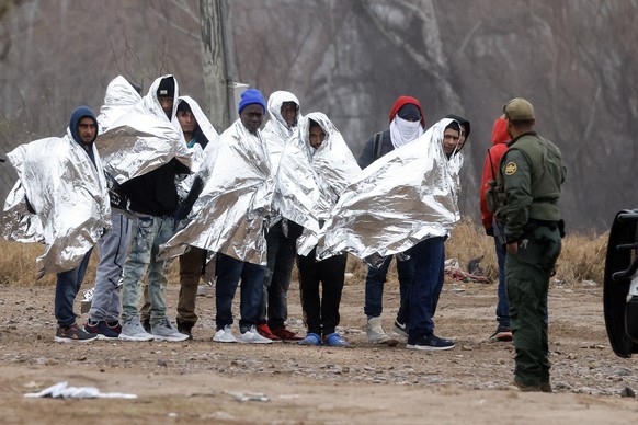 epa11076909 Migrants line up as they get ready to be picked up by Border Patrol agents in Eagle Pass, Texas, USA, 14 January 2024. The Texas Military Department confirmed that the Texas National Guard ...