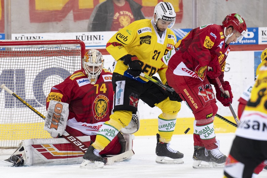 Tigers Goalie Ivars Punnenovs, links, und Yannick Blaser, rechts, kaempfen um den Puck gegen Berns Simon Moser, Mitte, waehrend dem Meisterschaftsspiel der National League zwischen den SCL Tigers und  ...